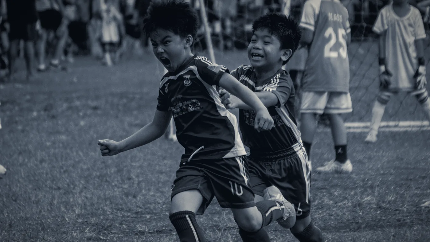 Dos niños disputando el balón con toda la intensidad del juego